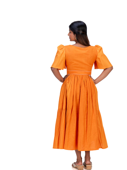 A woman shown from the back wearing a bright Pomo orange midi dress with short puff sleeves and a pleated skirt, standing against a plain white background.