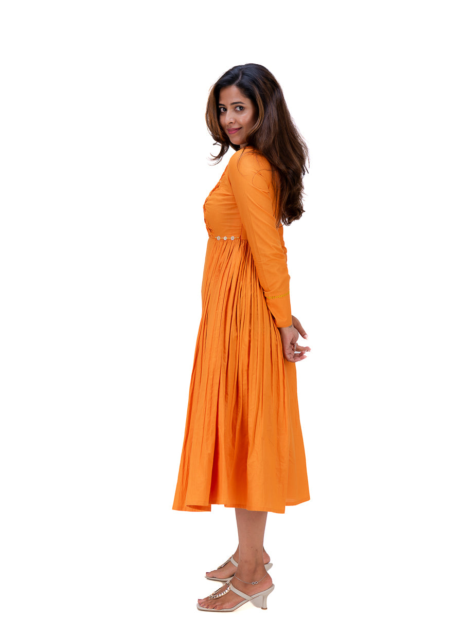 A woman modeling a bright Pomo orange long-sleeve midi dress with a pleated skirt and a thin decorative waistband, shown from a side-back angle against a plain white background.