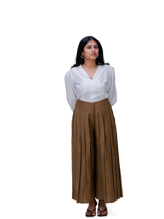 A woman modeling a white long-sleeve blouse and Oak Brown wide-leg pleated trousers against a plain white background.