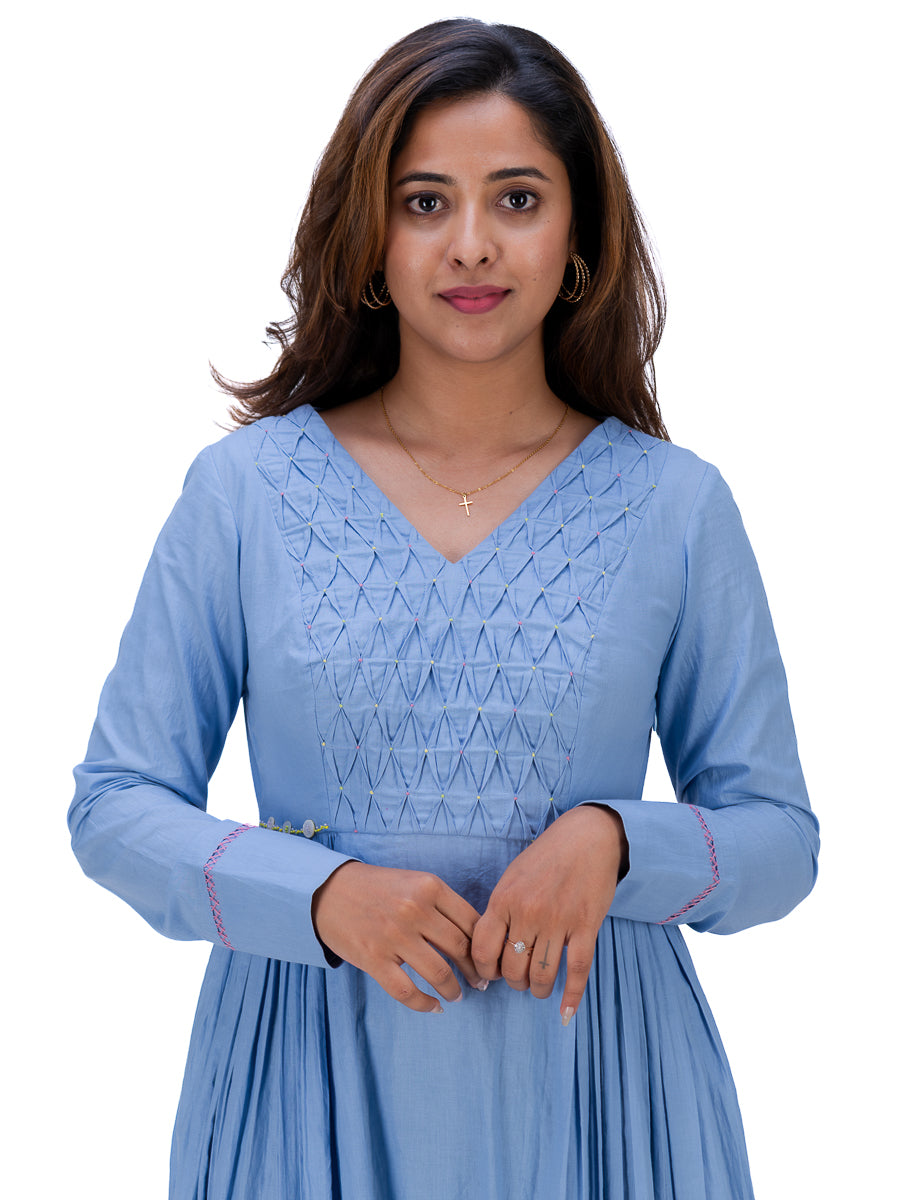 A woman wearing a light Nile Blue long-sleeve kurta with a V-neck and geometric embroidered detailing on the chest, shown against a plain white background.