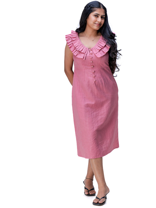 A woman modeling a Ash pink sleeveless midi dress with a ruffled neckline and front button detail, photographed against a plain white background.