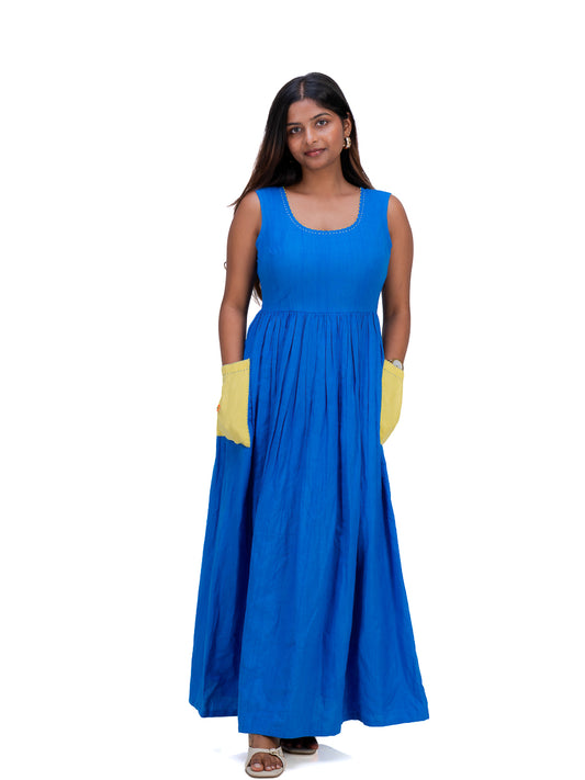 A woman modeling a sleeveless royal Woad Blue maxi dress with yellow contrast panels on the sleeves, shown against a plain white background.