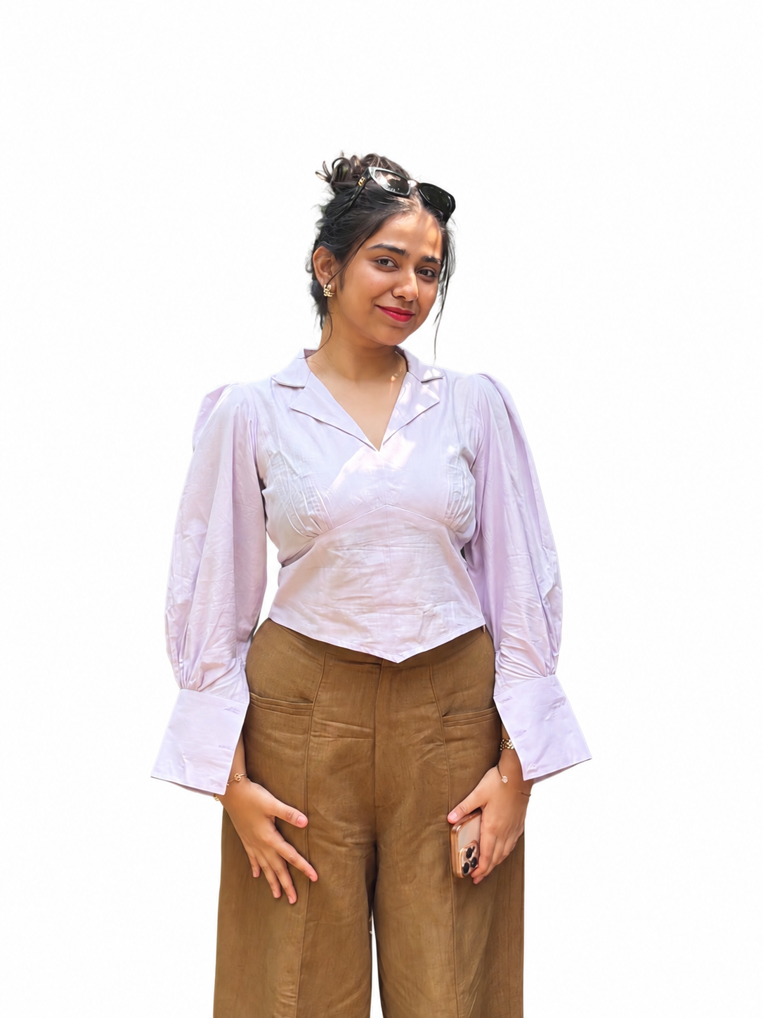 A woman modeling a Ash pink  long-sleeve blouse with a V-neck and gathered sleeves, paired with brown wide-leg trousers, against a plain background.
